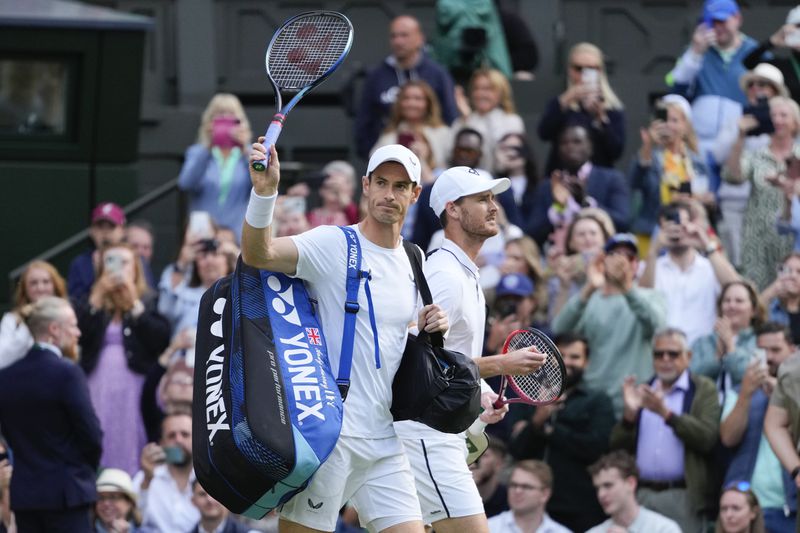 Andy, left, and Jamie Murray walk onto Centre Court for their first round doubles match against Australia's John Peers and Ricky Hijikata at the Wimbledon tennis championships in London, Thursday, July 4, 2024. (AP Photo/Kirsty Wigglesworth)