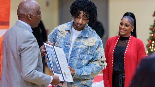 Rapper 21 Savage receives a copy of a resolution from State Representative Billy Mitchell on Wednesday, December 21, 2022. Dec. 21 was pronounced “21 Savage Day” in the state for the rapper’s philanthropic efforts. (Arvin Temkar / arvin.temkar@ajc.com)