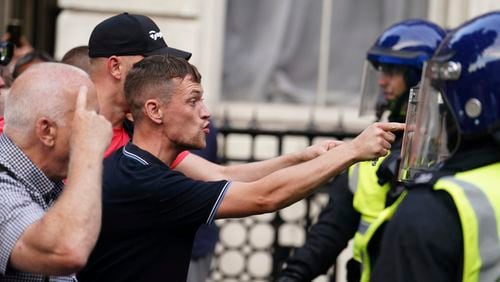Protesters confront police officers during the "Enough is Enough" protest in Whitehall, London, Wednesday July 31, 2024, following the fatal stabbing of three children at a Taylor Swift-themed summer holiday dance and yoga class on Monday in Southport. (Jordan Pettitt/PA via AP)