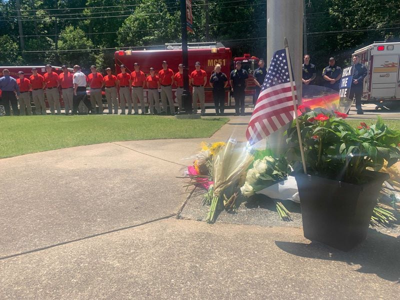 Firefighters stood at attention outside Holly Springs police headquarters Thursday afternoon as they paid their respects to a young officer killed in the line of duty.