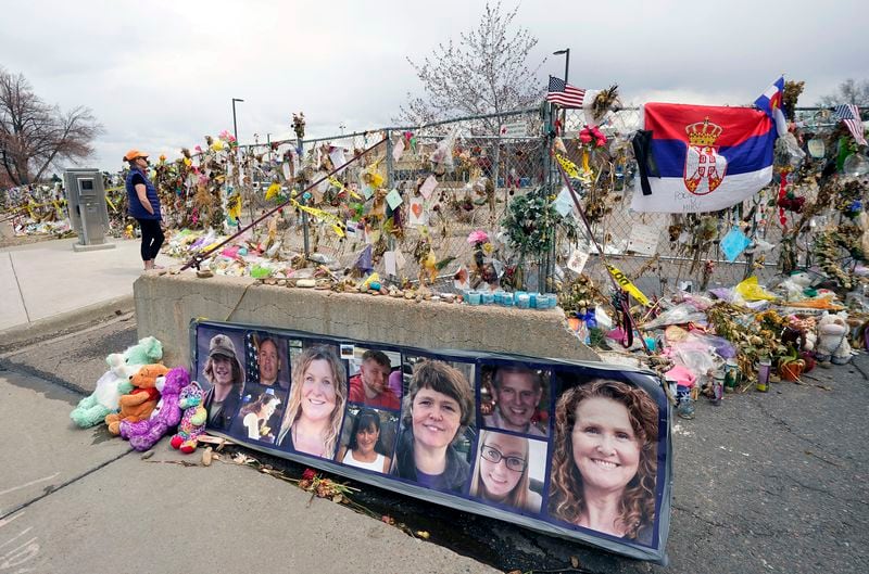 FILE - Pictures of the 10 victims of a mass shooting in a King Soopers grocery store are posted on a cement barrier outside the supermarket in Boulder, Colo., on April 23, 2021. (AP Photo/David Zalubowski, File)