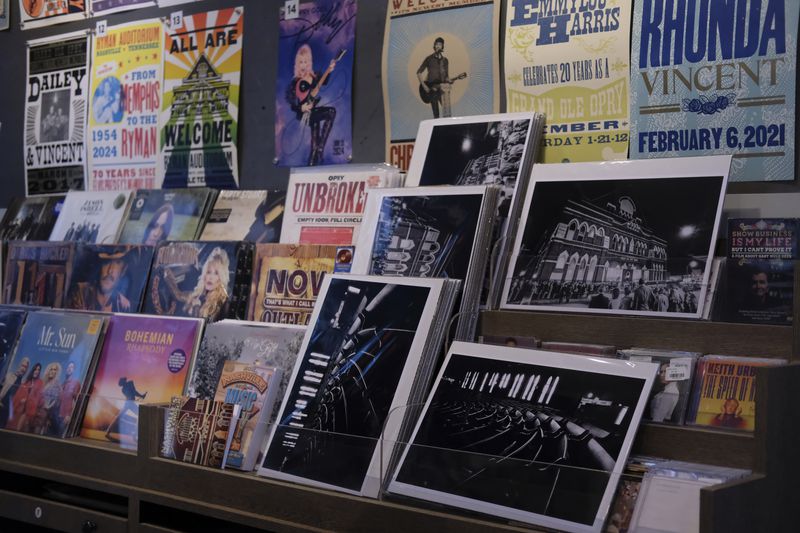 Posters of Dolly Parton and other artists who have played at the Ryman Auditorium are displayed at the concert venue's gift shop in Nashville, Tenn., on July 30, 2024. (AP Photo/Luis Andres Henao)