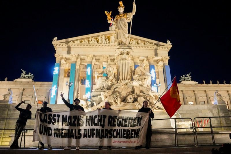 Anti right wing protesters shout slogans and hold an banner that reads "Don't let Nazis rule and never let them march" in front of the parliament building, in Vienna, Austria, Sunday, Sept. 29, 2024, after polls closed in the country's national election. (AP Photo/Andreea Alexandru)