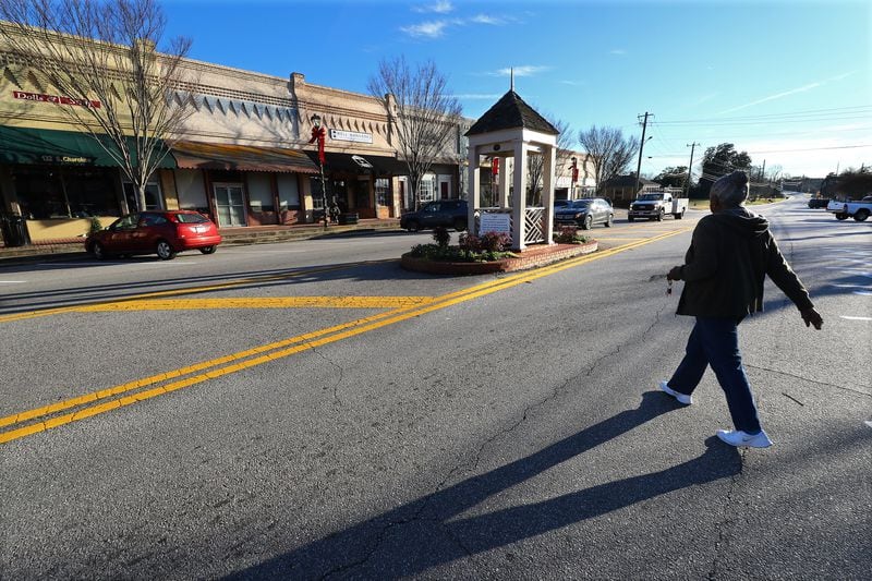  Local resident Ann Lowe, 78, doesn't need a cross-walk to make her way back to her car on the other side of the main drag in downtown Social Circle after going to a store in the small Georgia town on Tuesday, Jan. 18, 2022. (Curtis Compton / Curtis.Compton@ajc.com)`