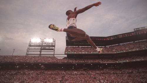 American Carl Lewis soars into first place during the long jump competition of the 1996 Atlanta Olympics on July 29, 1996, at Olympic Stadium in Atlanta. (Rich Addicks/AJC 1996)