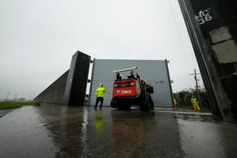 Workers from the Southeast Louisiana Flood Protection Authority-West close floodgates along the Harvey Canal, just outside the New Orleans city limits, in anticipation of Tropical Storm Francine, in Harvey, La., Tuesday, Sept. 10, 2024. (AP Photo/Gerald Herbert)