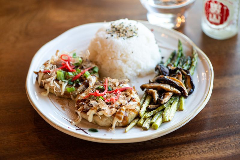 Lump Crab Cakes, topped with bonito flakes and a side of teppan grilled seasonal veggies. Photo credit- Mia Yakel.