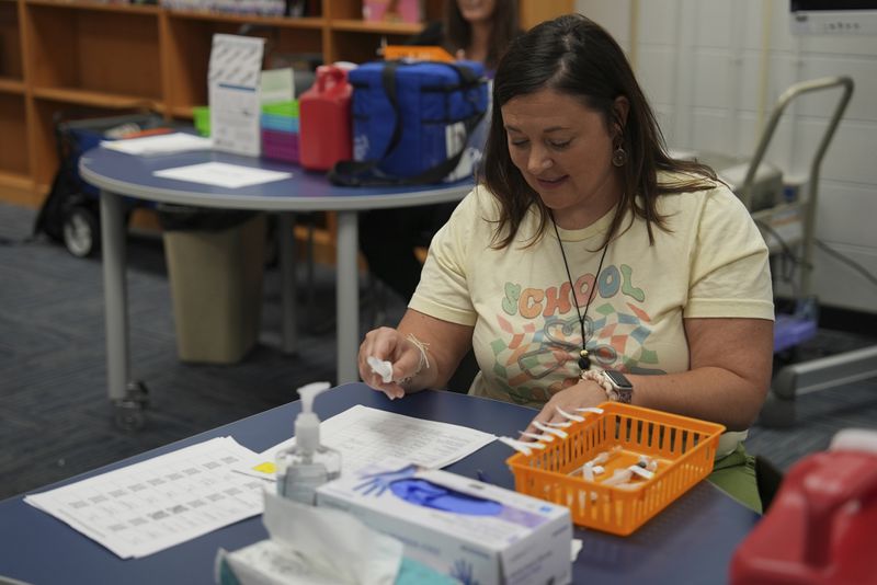 Angela Hayes, a nurse practitioner with Jefferson County Public Schools, prepares vaccines for students at Newcomer Academy in Louisville, Ky., on Thursday, Aug. 8, 2024. (AP Photo/Mary Conlon)