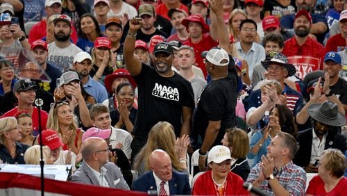 Two Black supporters are recognized by former President Donald Trump during a rally Saturday at the Georgia State University Convocation Center. In an apparent bid for Black votes, Trump has claimed on several occasions that immigrants are taking "Black jobs."  (Hyosub Shin / AJC)