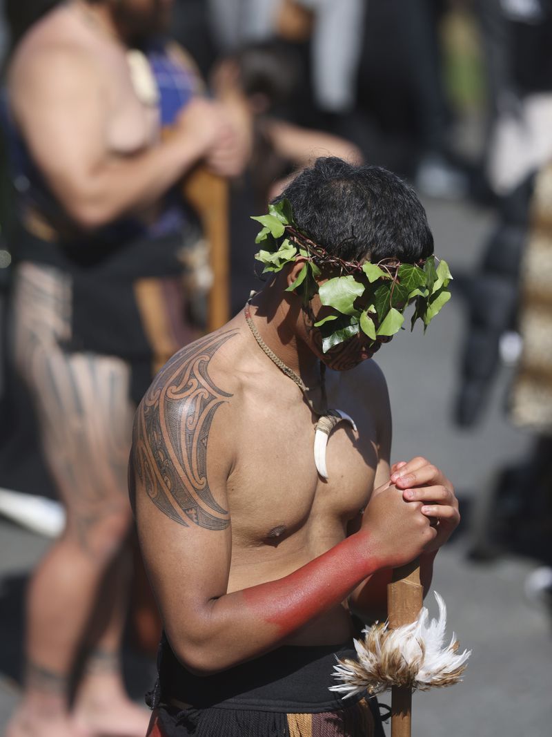 A warrior waits for the arrival of the coffin of New Zealand's Maori King, Kiingi Tuheitia Pootatau Te Wherowhero VII, before the burial in Ngaruawahia, New Zealand, Thursday, Sept. 5, 2024. (AP Photo/Alan Gibson)