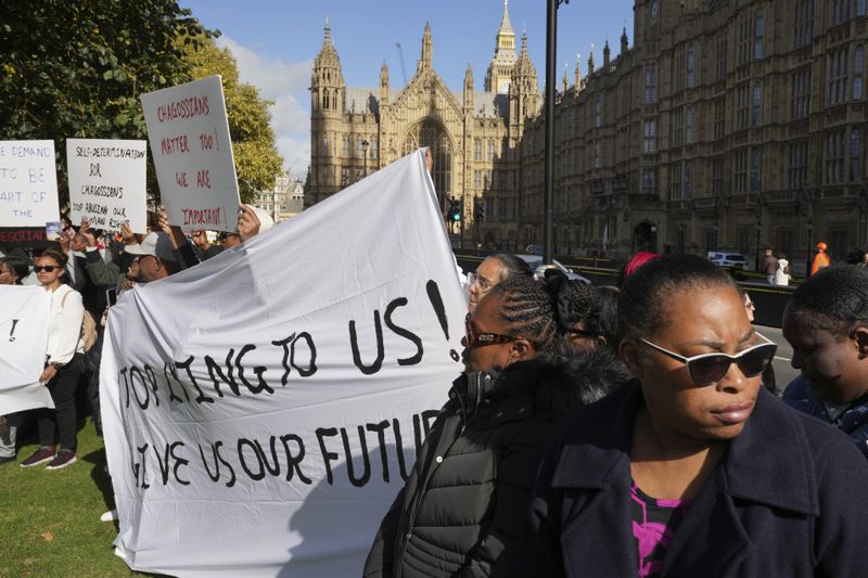 Chagossians attend a protest to response the U.K. announcement to agree to hand sovereignty of the long-contested Chagos Islands to Mauritius and against their "Exclusion" from Chagos negotiations, outside the House of Parliament, in London, Monday, Oct. 7, 2024. (AP Photo/Kin Cheung)