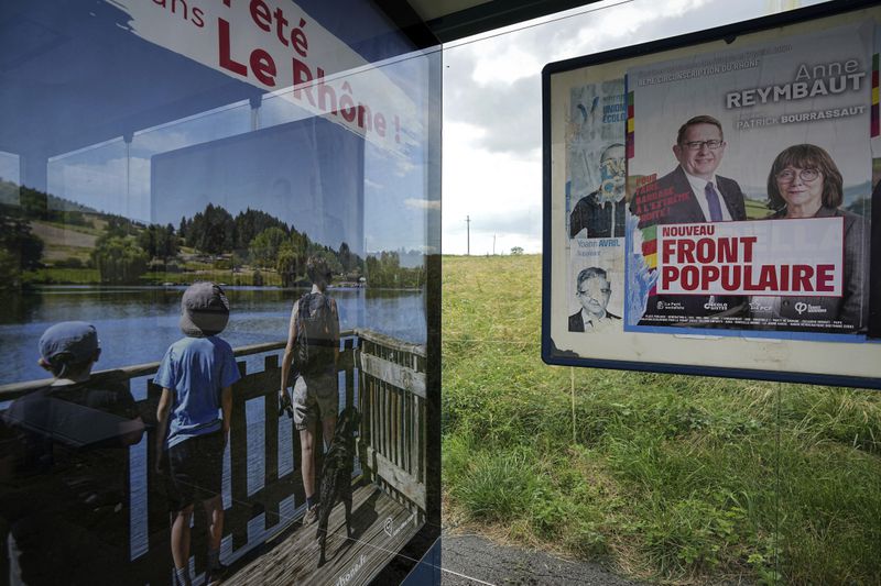 An electoral campaign board is set up in the countryside for the upcoming parliamentary elections, in Ville-sur-Jarnioux, central France, Tuesday, June 25, 2024. The upcoming two-round parliamentary election will take place on June 30 and July 7. (AP Photo/Laurent Cipriani)
