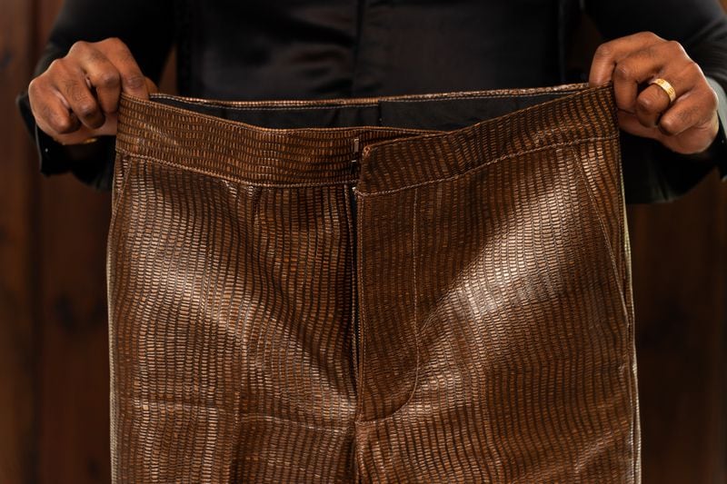 Tailor Carl Ulysses displays pants he made worn by Jamie Foxx in “They Cloned Tyrone” at The 500 Apartments in Atlanta on Friday, June 28, 2024. (Seeger Gray / AJC)