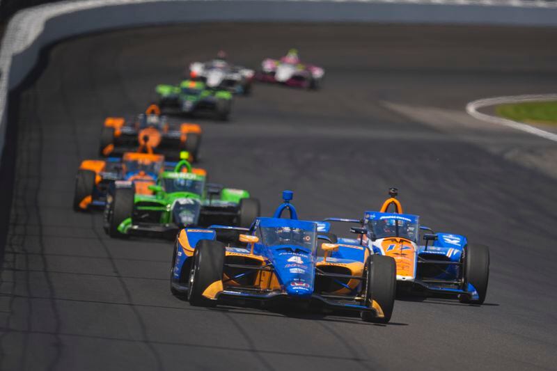 Kyffin Simpson (4) passes Kyle Larson (17) as he drives into the second turn during the final practice for the Indianapolis 500 auto race at Indianapolis Motor Speedway in Indianapolis, Friday, May 24, 2024. (AP Photo/Michael Conroy)