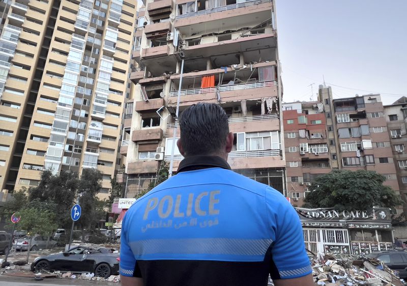 A Lebanese policeman looks at damaged apartments that were hit by Israeli strike early Monday, Sept. 30, 2024. (AP Photo/Hussein Malla)