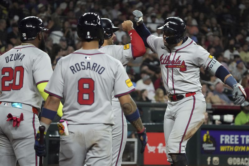 Atlanta Braves' Adam Duval, right, celebrates with Matt Olson, Marcell Ozuna (20), and Eddie Rosario (8) after hitting a three-run home run against the Arizona Diamondbacks in the sixth inning during a baseball game Tuesday, July 9, 2024, in Phoenix. (AP Photo/Rick Scuteri)