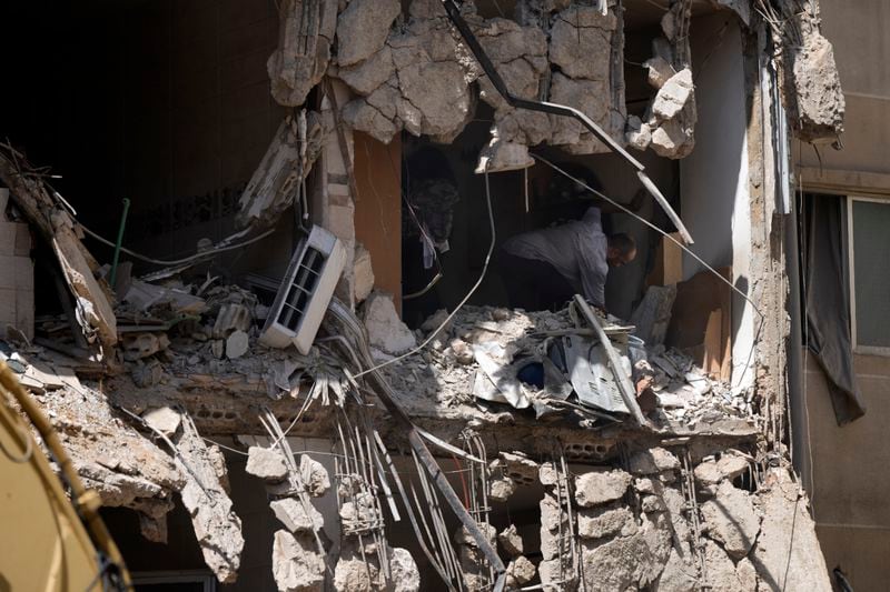 A couple try to salvage some of their belongings from a damaged apartment at the site of Friday's Israeli strike in Beirut's southern suburb, Sunday, Sept. 22, 2024. (AP Photo/Bilal Hussein)