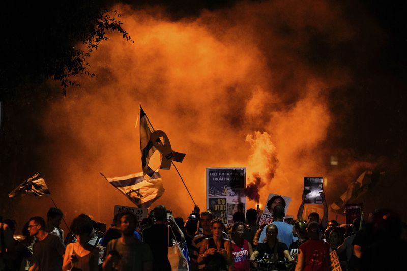 People attend a rally demanding a cease-fire deal and the immediate release of hostages held by Hamas in the Gaza Strip after the deaths of six hostages in the Palestinian territory in Tel Aviv, Israel, on Monday, Sept. 2, 2024. (AP Photo/Ariel Schalit)