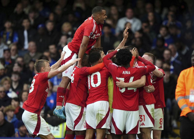 Nottingham Forest's Chris Wood celebrates scoring their side's first goal of the game with team-mates during the English Premier League soccer match between Chelsea and Nottingham Forest at Stamford Bridge in London, Sunday Oct. 6, 2024. (Bradley Collyer/PA via AP)