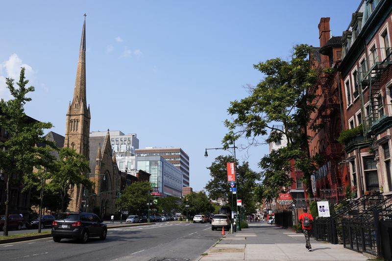 Cars make their way through the Harlem neighborhood of New York, Thursday, Aug. 15, 2024. (AP Photo/Pamela Smith)