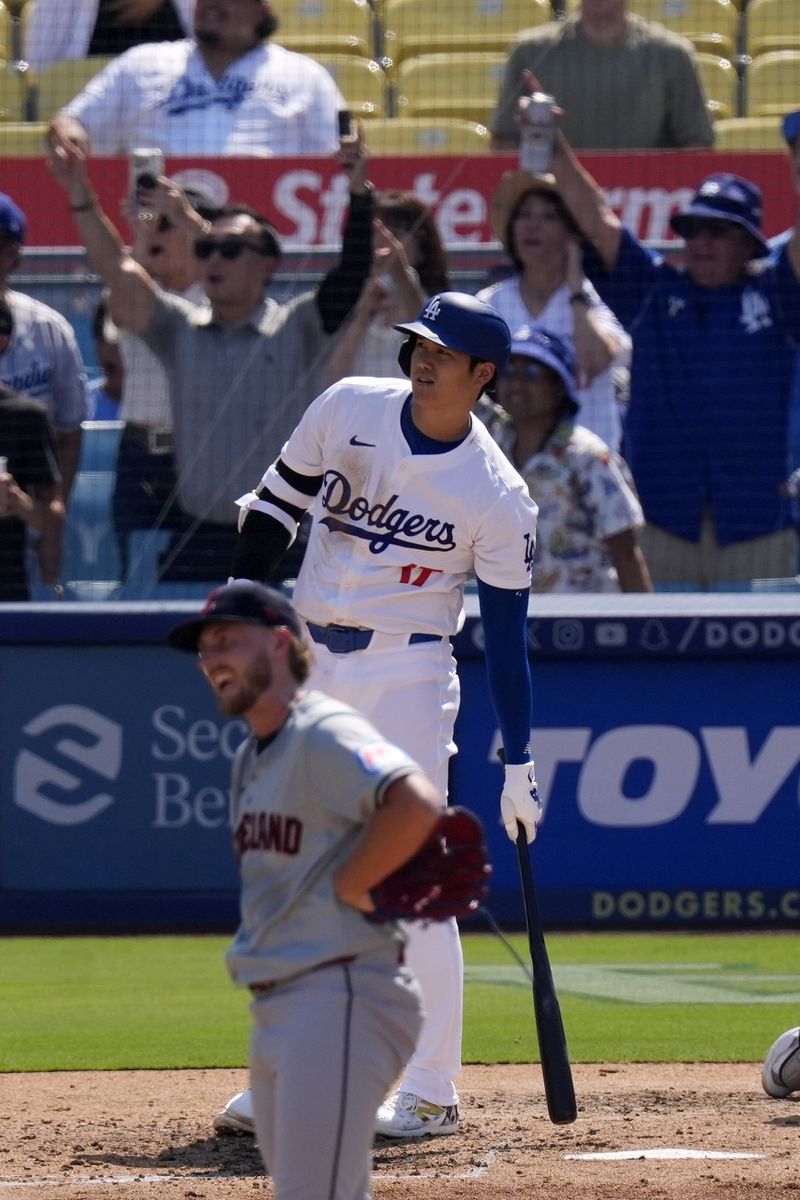 Los Angeles Dodgers' Shohei Ohtani, top, watches along with Cleveland Guardians starting pitcher Tanner Bibee as his ball goes out for a solo home run during the fifth inning of a baseball game, Sunday, Sept. 8, 2024, in Los Angeles. (AP Photo/Mark J. Terrill)