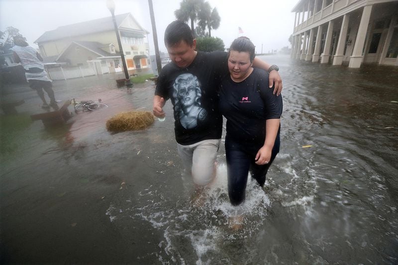 Residents Michael & Tori Munton make their way down a flooded street in historic Saint Marys during the storm surge from Hurricane Matthew. Made with Canon EOS 1DX Mark II camera, a 16-35mm zoom lens at 16 mm, 1/1000 second, F/5.6, ISO 5000.  Curtis Compton /ccompton@ajc.com