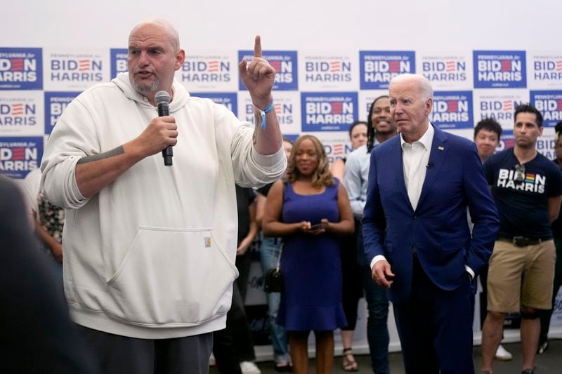 FILE - President Joe Biden, right, listens as Sen. John Fetterman, D-Pa., speaks at a campaign office in Philadelphia, July 7, 2024. It's been two weeks since Biden's debate with Donald Trump. On Thursday, July 11, the 11th lawmaker joined the list of Democrats calling on Biden to end his candidacy. After days of reckoning, many more are known to be harboring that wish. Many others in the party have stayed in line behind Biden. Fetterman stepped up to offer a full-throated defense of the president. He, too, had epically flopped in a debate. (AP Photo/Manuel Balce Ceneta, File)