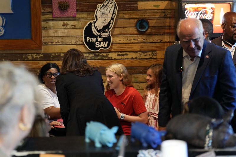 Democratic presidential nominee Vice President Kamala Harris and her running mate Minnesota Gov. Tim Walz talk as they visit SandFly Bar-B-Q in Savannah, Ga., Wednesday, Aug. 28, 2024. (AP Photo/Jacquelyn Martin)