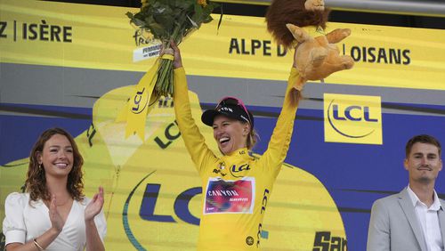 Tour de France Women's winner Katarzyna Niewiadoma of Poland, wearing the overall leader's yellow jersey, celebrates on the podium after the eighth stage of the Tour de France Women cycling race with start in Le Grand-Bornand and finish in Alpe d'Huez, France, Sunday, Aug. 18, 2024. (AP Photo/Peter Dejong)