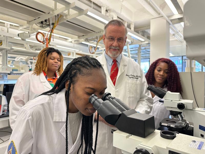 In this file photo, Dr. Barney Graham watches with Morehouse School of Medicine students Briana Brock, left and Dana Battle, right, as a Morehouse School of Medicine student looks into a microscope .