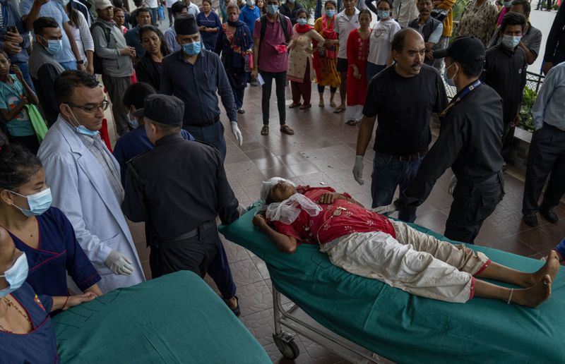 An injured woman is brought for treatment at a hospital, after a bus carrying Indian tourists fell into a river near Abukhaireni town about 75 miles west of the capital Kathmandu, Nepal, Friday, Aug. 23, 2024. (AP Photo/Niranjan Shrestha)