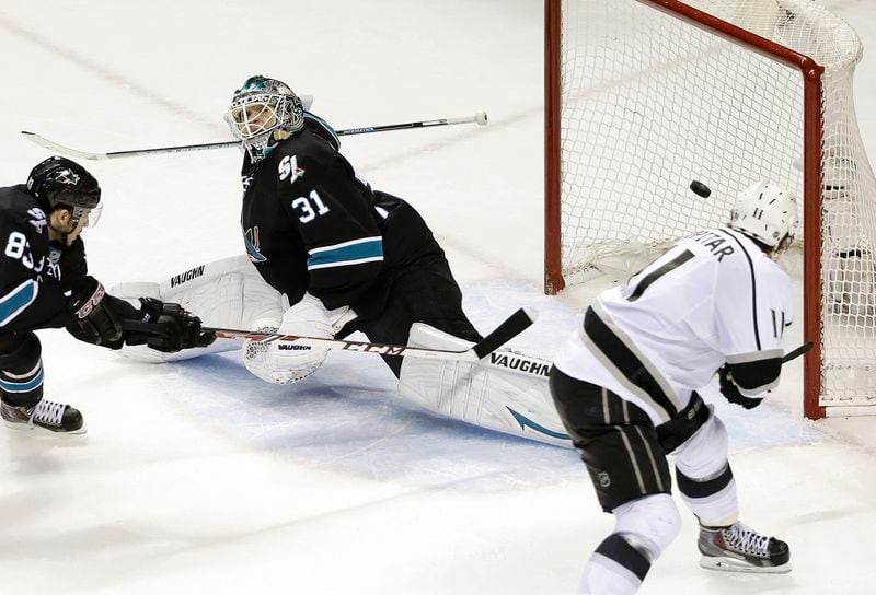 FILE - Los Angeles Kings center Anze Kopitar, right, scores a goal past San Jose Sharks goalie Antti Niemi (31) and left wing Matt Nieto (83) during the second period of Game 7 of an NHL hockey first-round playoff series in San Jose, Calif., April 30, 2014. The Kings trailed 3-0 in the series, but came back to win. (AP Photo, File)