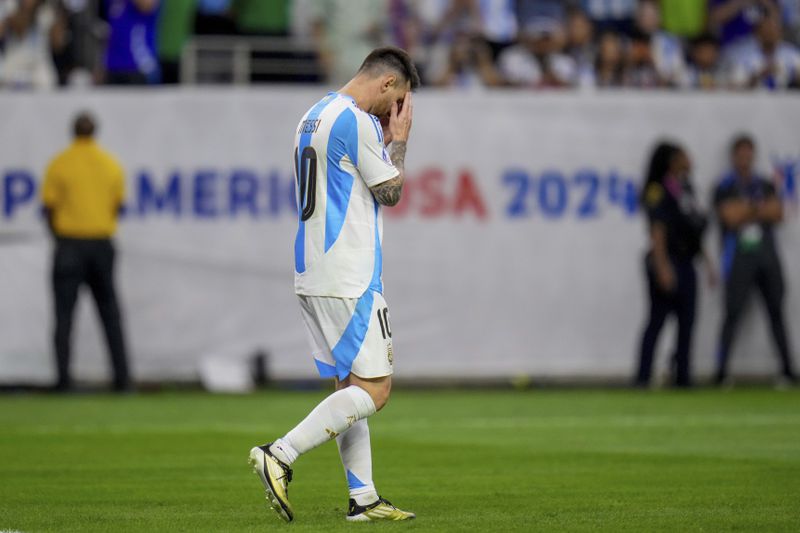Argentina's Lionel Messi holds his head after missing to score in a penalty shootout against Ecuador in a Copa America quarterfinal soccer match in Houston, Thursday, July 4, 2024. (AP Photo/Julio Cortez)