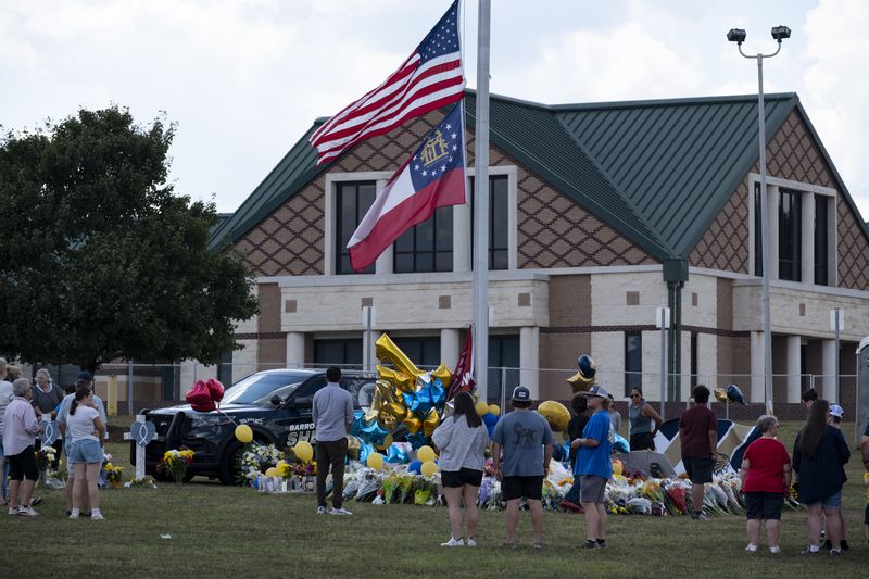 People visit a makeshift memorial in front of Apalachee High School in Winder on Saturday, Sept. 7, 2024.   (Ben Gray / Ben@BenGray.com)