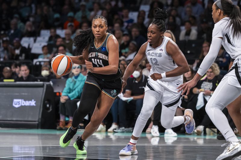 New York Liberty forward Betnijah Laney-Hamilton (44) is defended by Las Vegas Aces guard Chelsea Gray (12) during the first half of a WNBA basketball second-round playoff game, Sunday, Sept. 29, 2024, in New York. (AP Photo/Corey Sipkin)