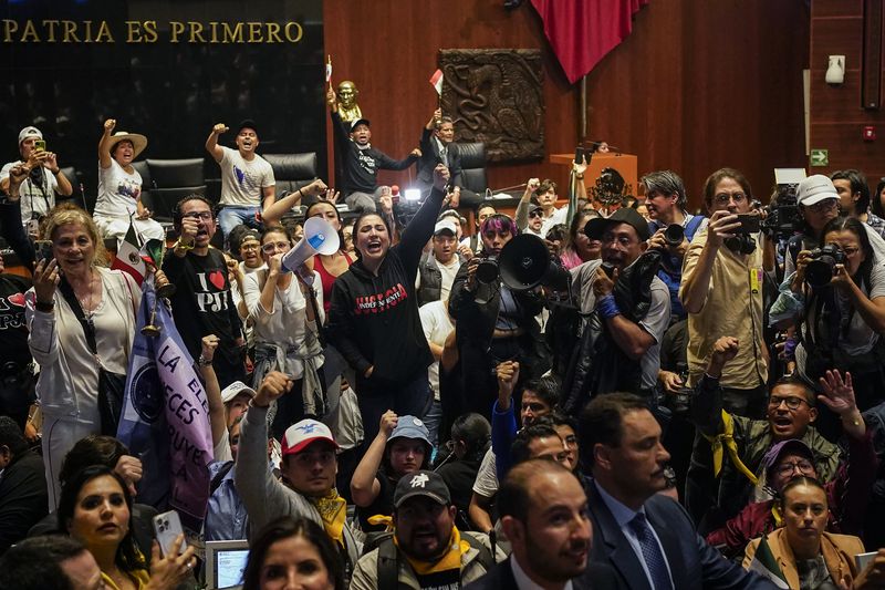 Protesters break into a Senate session in which lawmakers were debating the government's proposed judicial reform, which would make judges stand for election, in Mexico City, Tuesday, Sept. 10, 2024. (AP Photo/Felix Marquez)