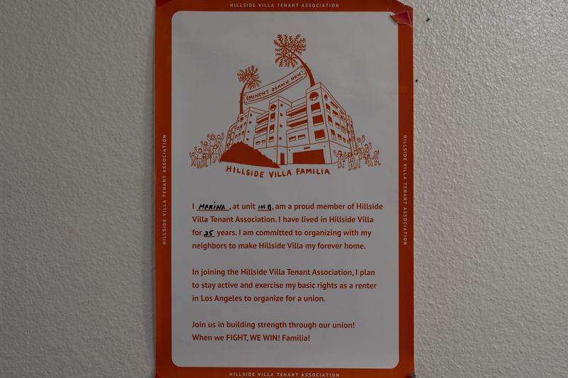 A poster symbolizing solidarity within the tenant community hangs on the wall of Marina Maalouf's apartment in Los Angeles, Tuesday, Oct. 1, 2024. Maalouf, a longtime Hillside Villa apartment complex resident, participated in protests after rents doubled in 2019. (AP Photo/Jae C. Hong)