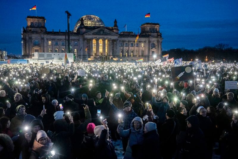 FILE - People hold up their cell phones as they protest against the AfD party and right-wing extremism in front of the Reichstag building in Berlin, Germany, Jan. 21, 2024. Some Germans are worried about the future of their country after Alternative for Germany, or AfD became the first far-right party to win a state election in post-World War II Germany. (AP Photo/Ebrahim Noroozi, File)