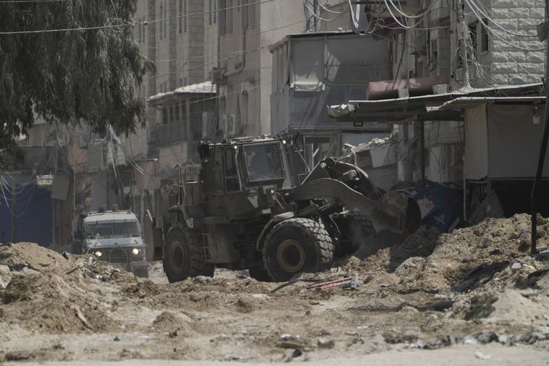 A bulldozer from the Israeli forces moves on a street during a military operation in the West Bank refugee camp of Nur Shams, Tulkarem, Thursday, Aug. 29, 2024. (AP Photo/Majdi Mohammed)