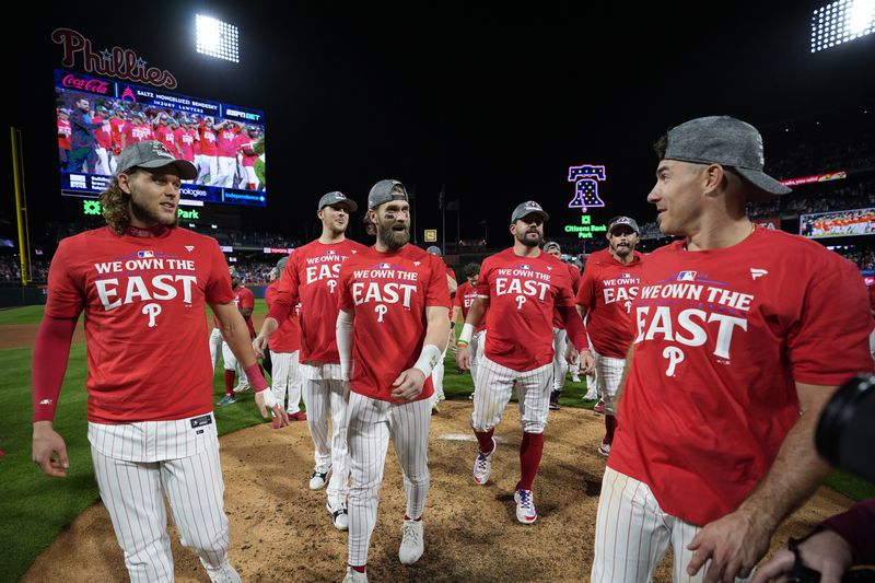 Philadelphia Phillies' Alec Bohm, from left, Jeff Hoffman, Bryce Harper, Kyle Schwarber, Garrett Stubbs and J.T. Realmuto celebrate after winning a baseball game against the Chicago Cubs to clinch the NL East title, Monday, Sept. 23, 2024, in Philadelphia. (AP Photo/Matt Slocum)