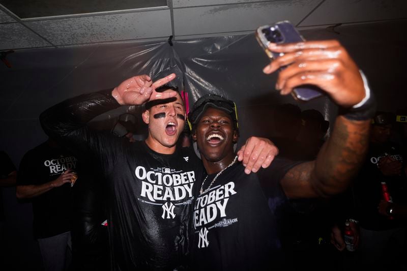 New York Yankees first baseman Anthony Rizzo, left, poses for a photo with third baseman Jazz Chisholm Jr., right, as they celebrate clinching a playoff spot after a 2-1 win in 10 innings over the Seattle Mariners in a baseball game Wednesday, Sept. 18, 2024, in Seattle. (AP Photo/Lindsey Wasson)