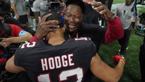 Atlanta Falcons head coach Raheem Morris hugs wide receiver KhaDarel Hodge (12) after Hodge scored the game-winning touchdown against the Tampa Bay Buccaneers during overtime in an NFL football game Friday, Oct. 4, 2024, in Atlanta. (AP Photo/John Bazemore)