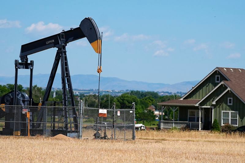 FILE - A pumpjack works on a pad near a housing development July 4, 2024, in Dacono, Colo. (AP Photo/David Zalubowski, File)