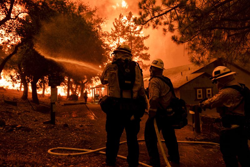 Firefighters battle the Airport Fire, Tuesday, Sept. 10, 2024, in El Cariso, an unincorporated community in Riverside County, Calif. (AP Photo/Etienne Laurent)