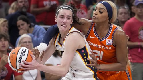 Connecticut Sun guard DiJonai Carrington (21) fouls Indiana Fever guard Caitlin Clark (22) in the second half of a WNBA basketball game in Indianapolis, Wednesday, Aug. 28, 2024. (AP Photo/Michael Conroy)