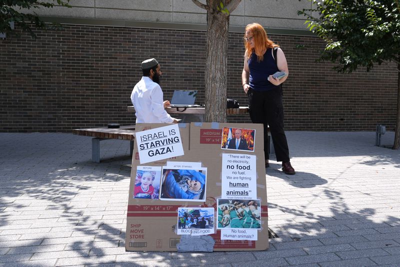 Activist Liz Rathburn, right, talks with University of Illinois-Chicago student Arsalan Zahid on campus Wednesday, Aug. 14, 2024, about two marches in support of Palestine, during the Democratic National Convention next week in Chicago. (AP Photo/Charles Rex Arbogast)