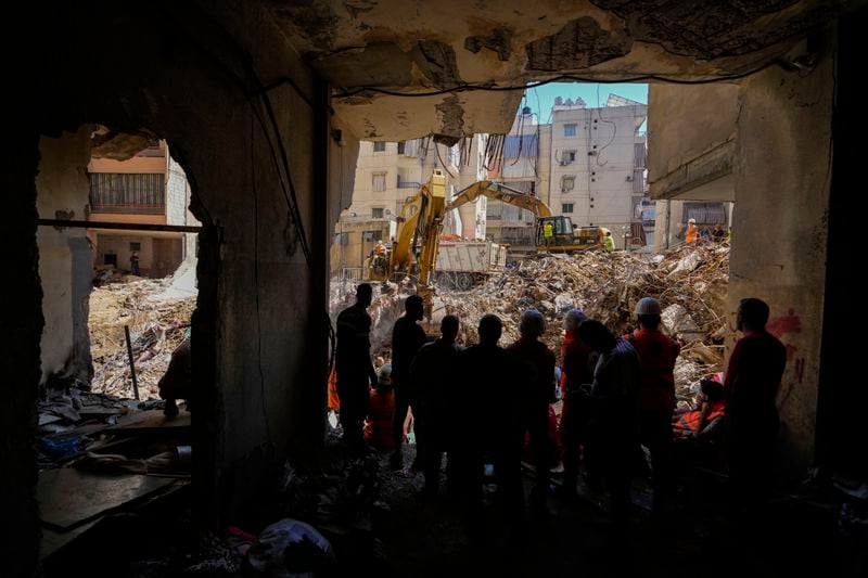 Emergency workers use excavators to clear the rubble at the site of Friday's Israeli strike in Beirut's southern suburbs, Lebanon, Monday, Sept. 23, 2024. (AP Photo/Hassan Ammar)