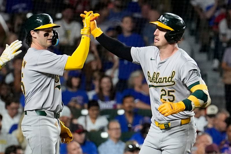 Oakland Athletics' Jacob Wilson, left, greets Brent Rooker at home after they both scored on Rooker's two-run home run off Chicago Cubs starting pitcher Shota Imanaga during the third inning of a baseball game Monday, Sept. 16, 2024, in Chicago. (AP Photo/Charles Rex Arbogast)