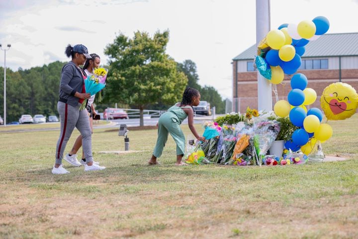  9-year-old Gianna White, along with 14-year-olds Alannah Parrish and Amy Lumpkin from Clark County, arrived at Apalachee High School to pay their respects. This was a day after a tragic event at a Barrow County high school, where a 14-year-old opened fire on Wednesday morning, resulting in the loss of two students and two teachers, as well as injuries to nine others. Thursday, Sep 5, 2024. (Miguel Martinez/AJC)