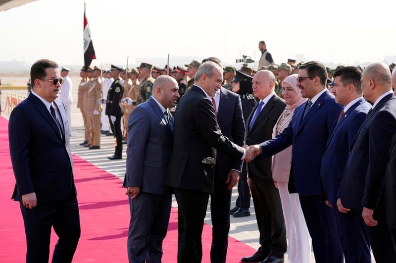 Iranian President Masoud Pezeshkian, center, is welcomed by Iraqi Prime Minister Mohammed Shia al-Sudani, left, with an official ceremony at the Baghdad International Airport in Baghdad, Iraq, Wednesday Sept. 11, 2024. (Murtadha Al-Sudani/Pool Photo via AP)